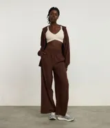 Pantalón deportivo de corte recto y holgado, color marrón, con cintura ancha elástica y pliegues frontales.