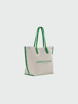 Bolso shopper Longchamp modelo Le Roseau Essential, color crudo con detalles en verde. Presenta logo de la marca en verde y doble asa de hombro.