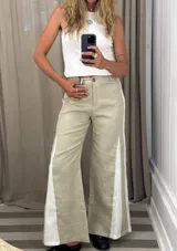 Pantalón de jean negro de pierna ancha con cortes laterales y godets triangulares en tela de broderie o encaje color crudo para mayor amplitud.