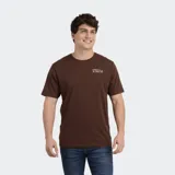 Remera de manga corta color marrón con cuello redondo. Presenta un pequeño logo estampado en el pecho con el nombre de la marca y motivos gráficos.