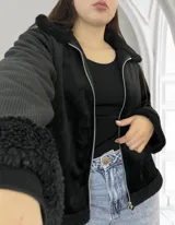 Campera negra de pana con cuello, puños y ruedo de corderito sintético. Cierre frontal con cremallera plateada.