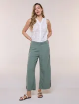 Pantalón crop de lino y rayón, con diseño wide leg de corte holgado, estampado tropical de hojas en tonos verde, azul y marrón sobre fondo blanco. Cuenta con pretina trasera elastizada y bolsillos delanteros.