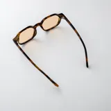 Lentes de sol Casimiro con armazón de policarbonato carey y cristales marrones claros. Presentan detalles metálicos dorados en las bisagras.