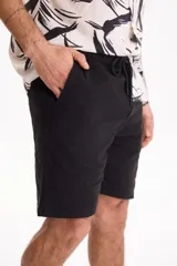 Bermuda de gabardina con spandex, cintura elastizada y cordón ajustable, de corte recto y color azul marino.