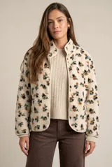 Campera de corderito con estampado floral, cuello alto y cierre frontal con botones a presión. Posee puños elásticos y un diseño de ajuste al cuerpo.