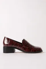 Mocasín de cuero con textura de reptil en color bordó, con puntera cuadrada y taco bloque bajo de color negro.