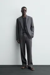 Pantalón de traje regular fit confeccionado en tejido de lino, con cierre frontal de cremallera y botón, bolsillos laterales y bolsillos traseros de vivo.