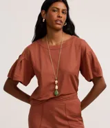 Blusa color ladrillo de tejido piquet con viscosa certificada, modelo t-shirt box, escote redondo y mangas cortas con pliegues.