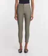 Pantalón tipo legging de mujer, color crema claro, confeccionado en poliuretano (PU) con un diseño liso. Presenta un cierre frontal con botones visibles en la cintura.