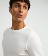 Remera negra de corte slim, cuello redondo y manga larga. Confeccionada en algodón con textura acanalada.