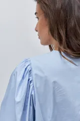 Camisa celesta de algodón con cuello mao, cierre frontal de botones y mangas abullonadas 3/4.