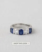 Anillo de plata 925 con diseño de medio sin fin, engastado con cinco piedras de circonia alternadas entre blancas y azul zafiro.