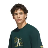 Remera de algodón color verde oscuro, con corte holgado y diseño de estampa gráfica en el pecho con estilo de cómic en color amarillo. Presenta el logo de Adidas en la manga.