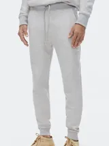 Pantalón tipo babucha de color azul oscuro, confeccionado con interior de felpa. Presenta cintura elástica con cordón de ajuste y puños acanalados en los tobillos.