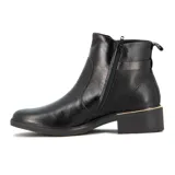 Bota de caña baja en cuero negro, con taco bajo cuadrado y detalle de hebilla dorada lateral. Presenta un detalle metálico dorado en la base del talón.