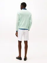 Sweater de cuello redondo color verde claro, confeccionado en algodón. Presenta logo bordado en el pecho, cuello, puños y bajo de punto canalé. Corte regular y hombros ligeramente caídos.