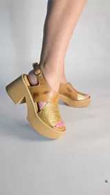 Sandalias de cuero color tostado con plataforma y taco ancho, con detalle de textura símil serpiente y acabado metalizado en la puntera. Cuenta con tira ajustable en el talón.