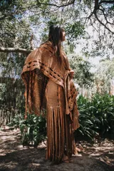 Pollera larga marrón de crochet con flecos y detalles en color naranja.