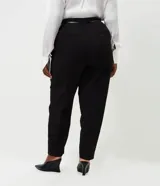 Pantalón de sastrería modelo carrot, de tiro alto y corte holgado en la cadera que se estrecha hacia el tobillo. Confeccionado en tejido estructurado con elastano, cuenta con bolsillos funcionales y cinturón fino incluido.