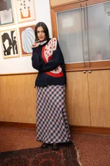 Buzo tejido de punto con diseño gráfico de granada en colores rojo y crema sobre base azul marino. Presenta silueta oversize, cuello redondo y calce relajado.