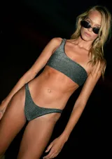 Conjunto de bikini plateado brillante, con corpiño de un solo hombro con hebilla metálica y bombacha vedetina.