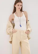 Jeans de corte wide leg en color beige, con tiro medio-alto, bolsillos clásicos y cierre frontal con botón y cremallera.
