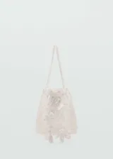 Bolso tipo saco color blanco, confeccionado en tejido de crochet con detalles de flores aplicadas, asas cortas de mano y diseño sin cierre.