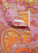 Pantalon de tiro medio con diseño acampanado y corte flare, confeccionado en tejido mezcla de lyocell y lino con estampado paisley en tonos naranja y rosado. Cuenta con cierre oculto de botón, gancho y cremallera, y bolsillos delanteros.