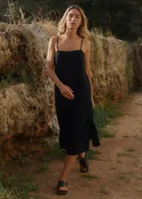 Vestido midi de lino y rayón, color negro, con escote recto, tirantes finos ajustables y tajo lateral.