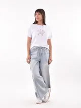 Remera color beige con estampa de texto 'Seaside Florida USA' y dibujo de coral en color lila.