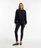 Pantalón legging negro de tiro alto, confeccionado en malla ponto roma, con cintura elástica y bandas laterales de acabado efecto cuero (cirre).