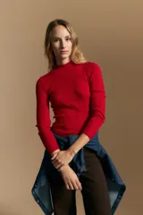 Polera de punto acanalado color gris, con cuello alto y mangas largas, de calce ajustado al cuerpo.