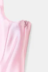 Top de breteles finos confeccionado en tejido satinado color rosa claro, con escote corazón y cierre lateral con cremallera oculta.