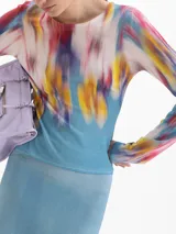 Top de punto ajustado de manga larga y escote redondo, con estampado floral difuminado en tonos azules, rojos y amarillos.