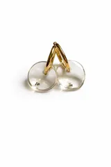 Aros de argolla dorada de acero quirúrgico con dije circular de resina traslúcida en tono gris humo y detalle de cristal incrustado.