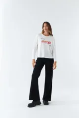 Remera blanca de algodón con mangas largas, cuello redondo y estampado con la frase 'look deeper always true art'.