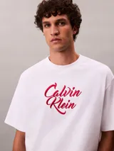 Remera Calvin Klein de corte relajado, confeccionada en algodón grueso blanco. Cuenta con cuello tipo mock y logo estampado en el pecho con tipografía cursiva en tono bordó.
