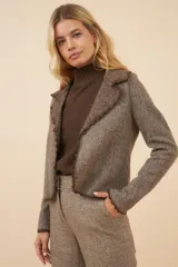 Chaqueta marrón de lana fina sin teñir, de corte recto con cuello solapa y mangas con corte en puño que permiten transformarla en manga 3/4.