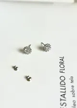 Par de caravanas plateadas con forma de flor, con circonitas incrustadas.