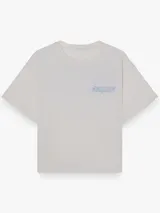 Remera boxy blanca de manga corta, con cuello redondo y estampa minimalista en el pecho, de corte relajado.