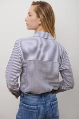 Camisa de mujer a rayas verticales blancas y rosadas, con cuello clásico, cierre de botones frontal y mangas largas con puños abotonados.