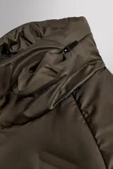 Cazadora deportiva acolchada color verde oscuro, con cuello alto y cierre frontal con cremallera. Cuenta con bolsillos laterales con cremallera oculta y un bolsillo interior.