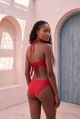 Conjunto de bikini color blanco marfil con corpiño tipo banda con tirante halter y bombacha de corte clásico.