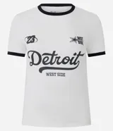 Remera ajustada de manga corta color blanco con ribetes negros en cuello y mangas. Presenta un estampado frontal con la palabra "Detroit" en tipografía cursiva grande, y texto más pequeño que dice "WEST SIDE" debajo. También incluye el número "23" y un logo con una estrella y el texto "WST SIDE".