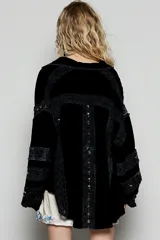 Blusa blanca de corte amplio con cuello camisero y cierre frontal de botones. Presenta detalles de encaje calado (broderie) en los bordes y en las mangas estilo kimono.