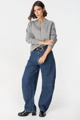 Saco tipo cardigan de punto color crudo, con cuello redondo, cierre frontal de botones y mangas largas con puños acanalados.