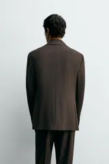 Blazer de corte slim fit con cuello de solapas de muesca, manga larga con puños abotonados, bolsillo de vivo en el pecho y bolsillos de solapa en la cadera. Presenta cierre frontal con botones y aberturas en la espalda.