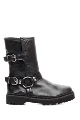 Bota de caña media confeccionada en cuero negro, con suela track dentada. Presenta un diseño con dos correas ajustables con hebillas metálicas y un detalle de argolla metálica en la parte inferior, además de cierre lateral.