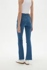 Pantalon jean de corte flare y tiro alto, con diseño liso y ruedo desflecado.