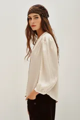 Camisa color crema de manga larga con cuello mao, botones a tono y frunces en mangas, espalda y hombros.